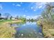 Scenic pond view reflects the clear sky, surrounded by natural vegetation for a peaceful community ambiance at 12125 Bannock St # C, Westminster, CO 80234