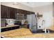 Stylish kitchen featuring stainless steel appliances, granite countertops, and dark wood cabinetry at 12744 Leyden St # F, Thornton, CO 80602