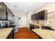 Well-lit kitchen features dark cabinets, stainless steel appliances, and beautiful granite countertops at 12744 Leyden St # F, Thornton, CO 80602