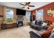 Bright living room featuring a fireplace, large windows, a ceiling fan, and comfortable seating at 12744 Leyden St # F, Thornton, CO 80602
