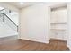 Open living room with wood-look floors, white walls, and staircase visible in the background at 13750 Emerald Lake St, Parker, CO 80138