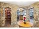 Basement features stone arches, a bookcase, a bar with wine cooler, and a view into the living room at 6194 Falcon Ridge Way, Morrison, CO 80465