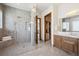 Modern bathroom with a glass-enclosed shower, dual shower heads, and elegant tile work at 6194 Falcon Ridge Way, Morrison, CO 80465