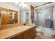 This bathroom features a glass-enclosed shower, vanity with sink, and tile countertops at 6194 Falcon Ridge Way, Morrison, CO 80465