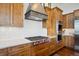 Detailed shot of the kitchen showcasing custom wood cabinets, a stainless steel range, and white subway tile backsplash at 6194 Falcon Ridge Way, Morrison, CO 80465