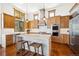 Spacious kitchen featuring custom wood cabinets, a central island with seating, and stainless steel appliances at 6194 Falcon Ridge Way, Morrison, CO 80465