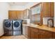 Modern laundry room with a front load washer and dryer, sink and ample wood cabinetry at 6194 Falcon Ridge Way, Morrison, CO 80465
