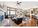 Bright living room with hardwood floors, a stone fireplace, and large windows showcasing stunning mountain views at 6194 Falcon Ridge Way, Morrison, CO 80465