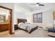 Spacious main bedroom with a tray ceiling, ceiling fan, window shutters, and ensuite bathroom at 6194 Falcon Ridge Way, Morrison, CO 80465