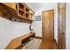 Mudroom with built-in storage bench, coat hooks, shelves, and a wooden door at 6194 Falcon Ridge Way, Morrison, CO 80465