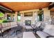 Covered outdoor seating area with a stone fireplace, furniture, and a wood paneled ceiling at 6194 Falcon Ridge Way, Morrison, CO 80465