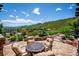 Scenic patio area with comfortable seating, overlooking a lush green landscape with rolling hills at 6194 Falcon Ridge Way, Morrison, CO 80465