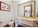 Charming powder room with a stone sink, decorative mirror, and hardwood floors at 6194 Falcon Ridge Way, Morrison, CO 80465