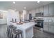 Contemporary kitchen with an island, stainless steel appliances, and stylish gray cabinetry at 13588 E 103Rd Pl, Commerce City, CO 80022