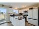 Modern kitchen features stainless steel appliances, white cabinetry, and dark countertops with an adjacent breakfast bar at 11058 Grange Creek Dr, Thornton, CO 80233