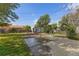 Grassy backyard features a basketball court and storage shed, perfect for outdoor recreation at 6751 Locust St, Commerce City, CO 80022