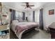 Bright bedroom with queen-sized bed, ceiling fan, and natural light from windows at 6751 Locust St, Commerce City, CO 80022
