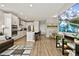 Bright, open-concept kitchen featuring white cabinetry, stainless steel appliances, and a center island with bar seating at 7875 Yampa River Ave, Littleton, CO 80125