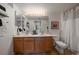 Bright bathroom with double sink vanity, large mirror with modern lighting, and tiled shower/tub at 8615 W Berry Ave # 204, Littleton, CO 80123