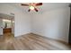 Bright bedroom offers light wood floors, a modern ceiling fan, and adjacent access to a well-lit bathroom at 8615 W Berry Ave # 204, Littleton, CO 80123