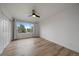 Bright bedroom features wood floors, a modern ceiling fan and a large window with treed neighborhood views at 8615 W Berry Ave # 204, Littleton, CO 80123