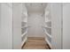 Spacious walk-in closet features ample shelving on both sides and light wood flooring at 8615 W Berry Ave # 204, Littleton, CO 80123