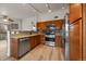 Well-lit kitchen with stainless appliances, light wood floors, granite countertops and attractive mosaic backsplash near dining area at 8615 W Berry Ave # 204, Littleton, CO 80123