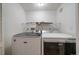 Clean laundry room features a modern washer and dryer with overhead shelving at 8615 W Berry Ave # 204, Littleton, CO 80123