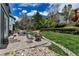 Cozy backyard patio features a fire pit, comfortable seating, and lush green grass at 25245 E Park Crescent Dr, Aurora, CO 80016