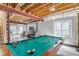 Unfinished basement with exposed beams, large windows, and a pool table, offering potential for customization at 25245 E Park Crescent Dr, Aurora, CO 80016