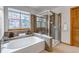 Bathroom showcasing a soaking tub, separate glass shower, and large window with blinds at 25245 E Park Crescent Dr, Aurora, CO 80016