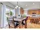 Sunlit dining area showcases hardwood floors and modern lighting with a sliding glass door that allows for indoor/outdoor lifestyle at 25245 E Park Crescent Dr, Aurora, CO 80016