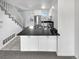 Modern kitchen with white cabinetry, stainless steel appliances, and a stylish black countertop island at 1622 S Idalia Cir # G, Aurora, CO 80017