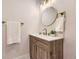 Stylish bathroom features modern fixtures, a round mirror, and wooden vanity at 1640 Iola St, Aurora, CO 80010