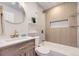 Charming bathroom with wooden accents, a round mirror, and a shower-tub combination at 1640 Iola St, Aurora, CO 80010