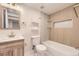 Well-lit bathroom with a new vanity, wood-look tiling in the shower and a built-in alcove at 1640 Iola St, Aurora, CO 80010