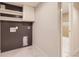 Newly remodeled laundry room with grey shiplap, white shelves and tile flooring at 1640 Iola St, Aurora, CO 80010