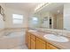 Bright bathroom featuring double sinks, a bathtub, and tile flooring at 427 S Parkside Dr, Longmont, CO 80501