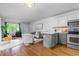 Open concept kitchen and living area with hardwood floors and modern appliances at 857 S Van Gordon E104 Ct # E104, Lakewood, CO 80228