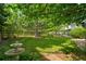 Green backyard lawn with a fountain, and mature trees offering shade and privacy at 10356 Lions Heart, Lone Tree, CO 80124