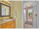 A bathroom features a wooden vanity with a view into the primary bedroom at 10356 Lions Heart, Lone Tree, CO 80124