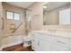 Bright bathroom with marble tile, a shower-tub, and a white vanity at 10505 Clarkson St, Northglenn, CO 80233