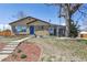 Charming single-story home with tan siding, brick accents, blue front door, and well maintained front yard at 10505 Clarkson St, Northglenn, CO 80233