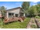 Backyard showing a wooden deck, mature trees, green lawn and rock feature at 10553 Stonemeadow Dr, Parker, CO 80134