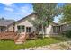 The backyard features a wooden deck, lush green lawn, mature trees, and decorative rock border at 10553 Stonemeadow Dr, Parker, CO 80134