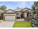 Charming single-Gathering home showcasing a well-maintained lawn, two-car garage, and inviting front entrance at 10553 Stonemeadow Dr, Parker, CO 80134