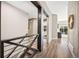 Bright hallway with wood floors, staircase, and natural light leading to a bedroom and a living area at 10553 Stonemeadow Dr, Parker, CO 80134