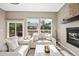 Cozy living room features comfortable seating, a fireplace, and large windows overlooking the backyard at 10553 Stonemeadow Dr, Parker, CO 80134
