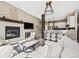Bright open-concept living room featuring a fireplace, modern lighting, and seamless flow into the kitchen at 10553 Stonemeadow Dr, Parker, CO 80134