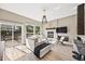 Sunlit living room with a fireplace, modern decor, and sliding glass doors leading to outdoor deck at 10553 Stonemeadow Dr, Parker, CO 80134
